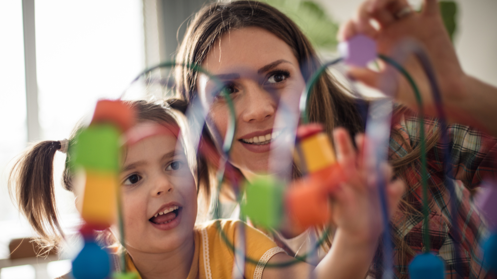 Early Years Teacher playing outdoors with nursery children 