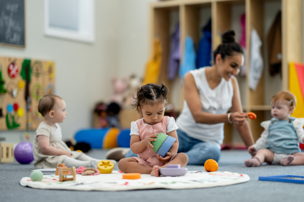 Early Years Educator playing on floor with children