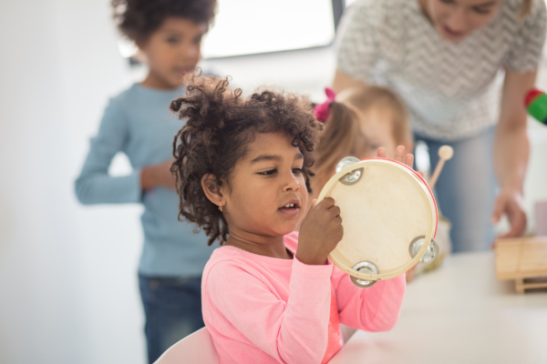 Child holding a tambourine in a nursery